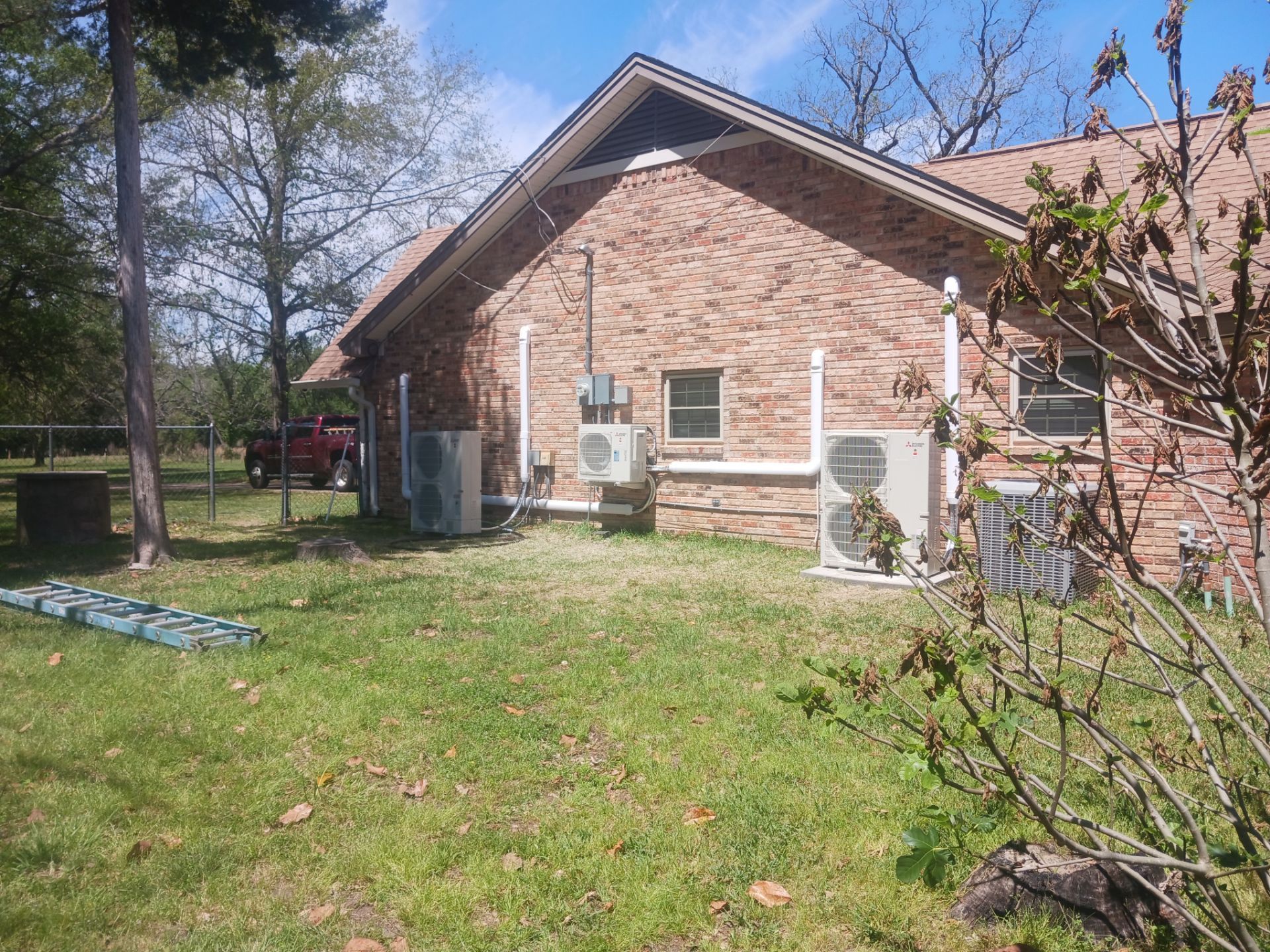 Installed outdoor mini split condensers on the sun-exposed side of a Houston brick home